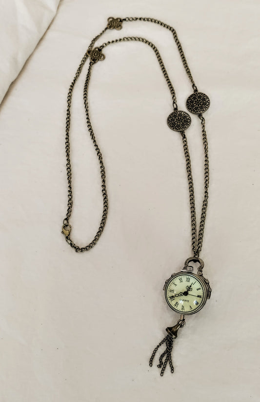 Necklace with a clock pendant on a beige background