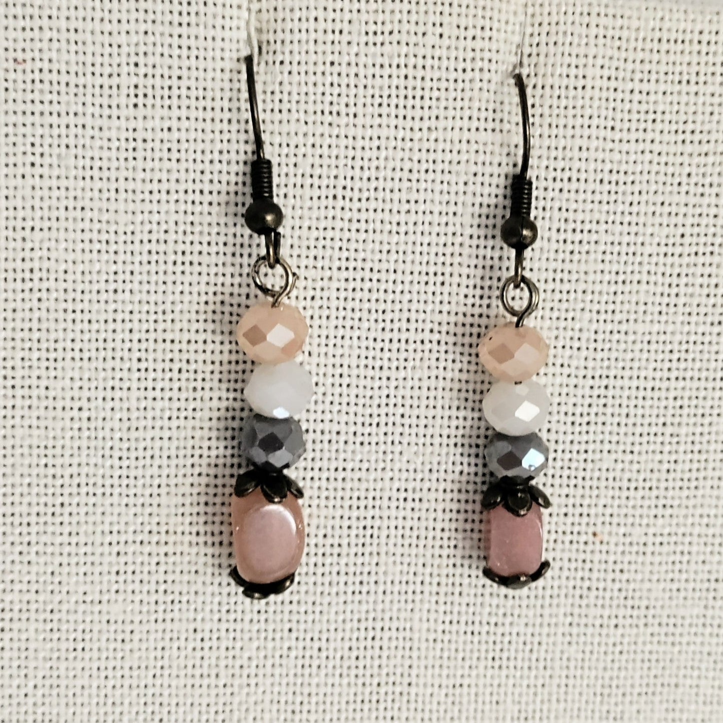 Pair of beaded earrings on a textured beige background