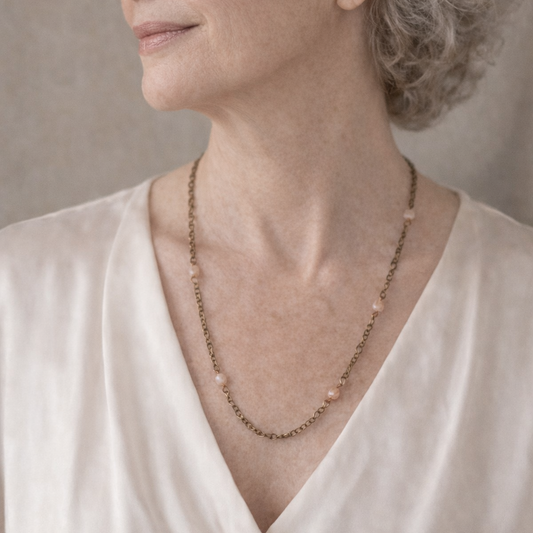 Woman wearing a necklace against a neutral background