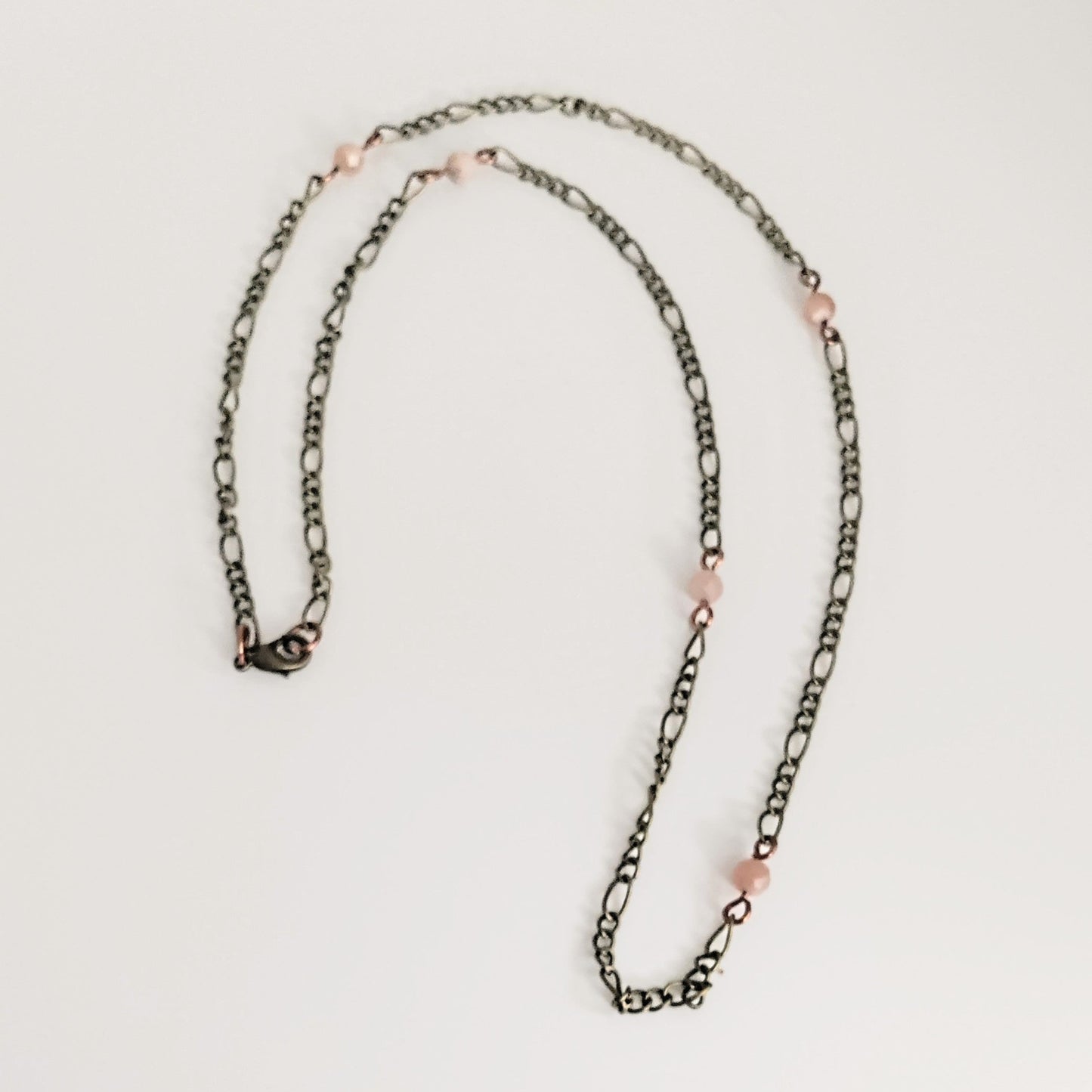 Necklace with pink beads on a light gray background