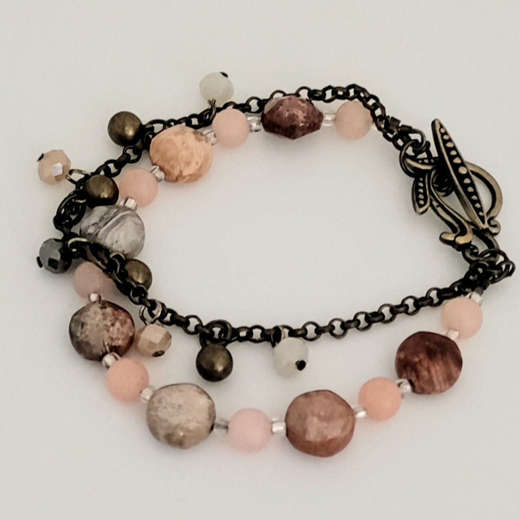 Bracelet with multicolored beads and chain on a light background