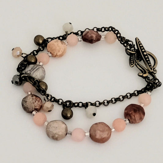 Bracelet with multicolored beads and chain on a light background