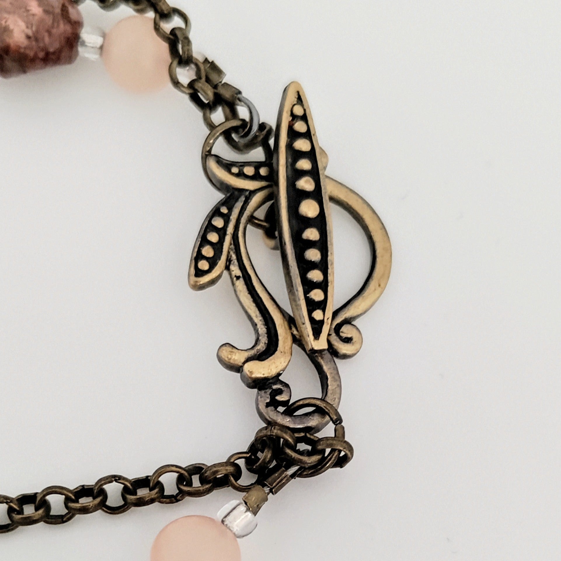 Bracelet with decorative clasp and pink beads on a light background