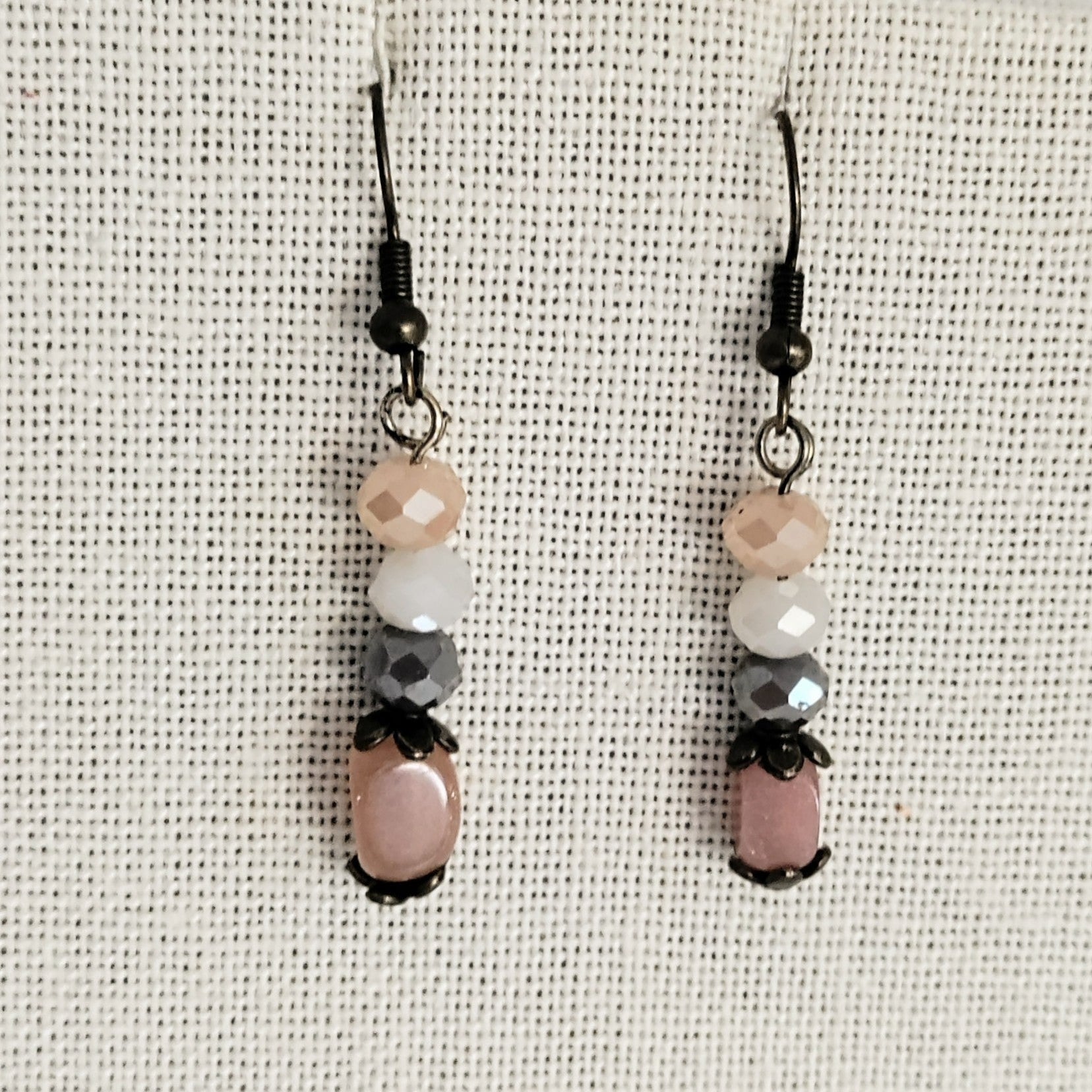 Pair of beaded earrings on a textured beige background